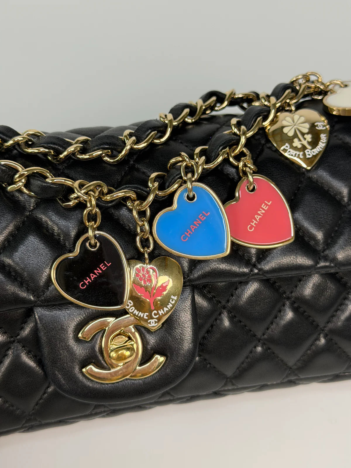 CHANEL EAST WEST CHARMS BAG IN BLACK LAMBSKIN LEATHER WITH GOLD HARDWARE